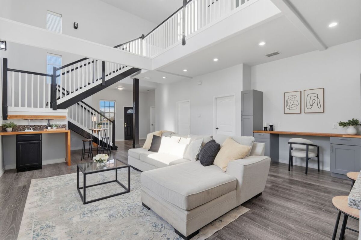 Living room with two-story ceiling and loft above